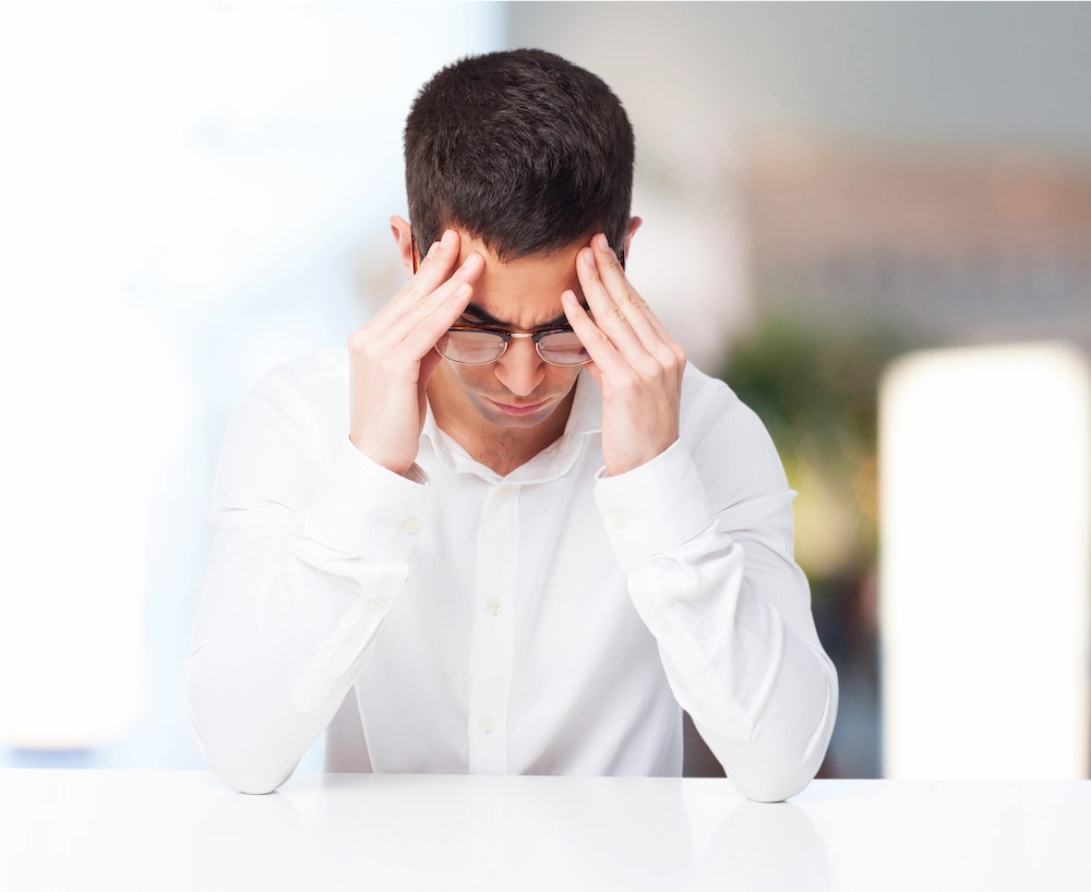 Person holding head in pain due to recurring headaches and tension